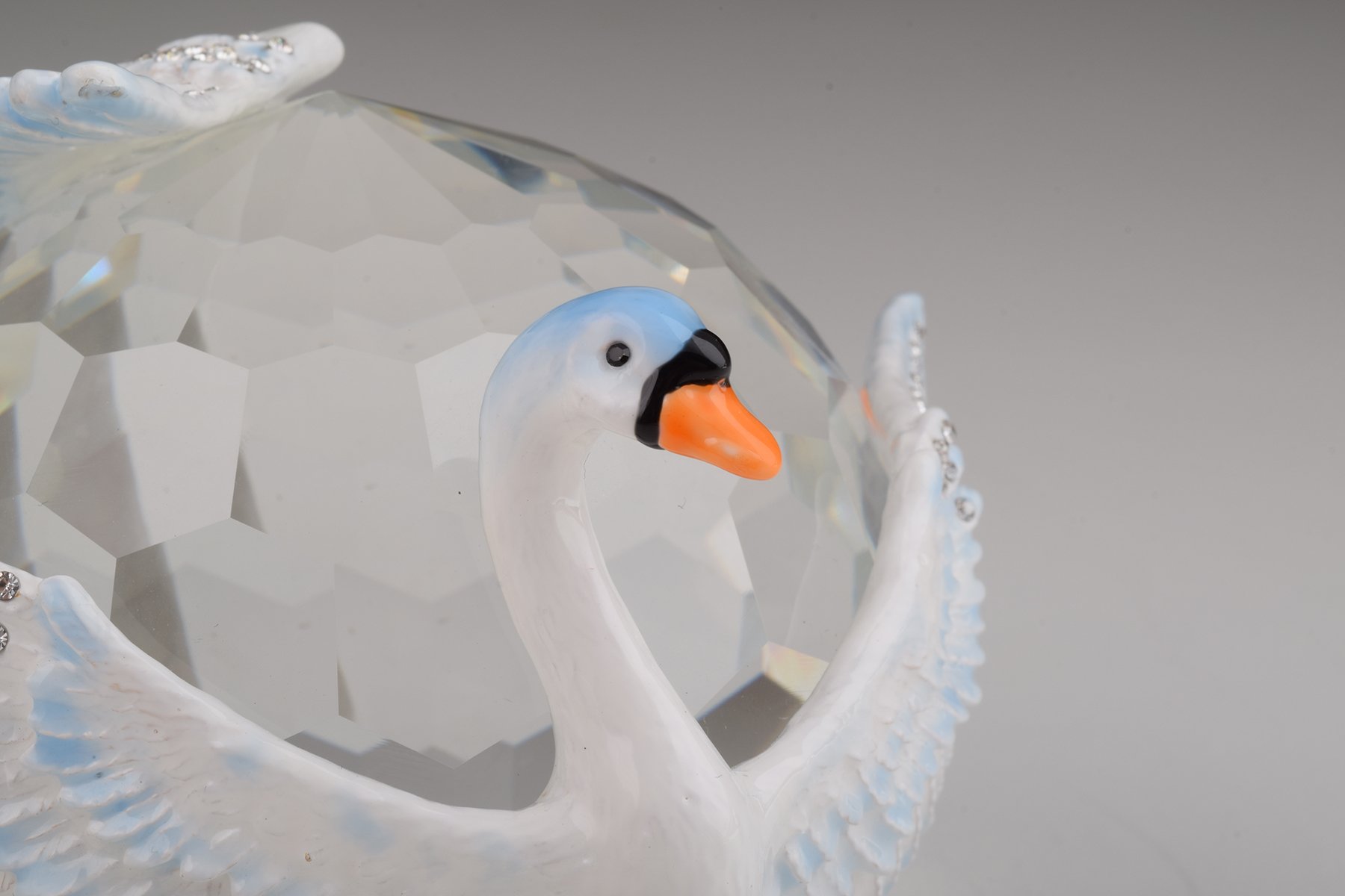 Elegant trinket box featuring two white swans on a crystal ball, adorned with Austrian crystals and plated with gold or silver.