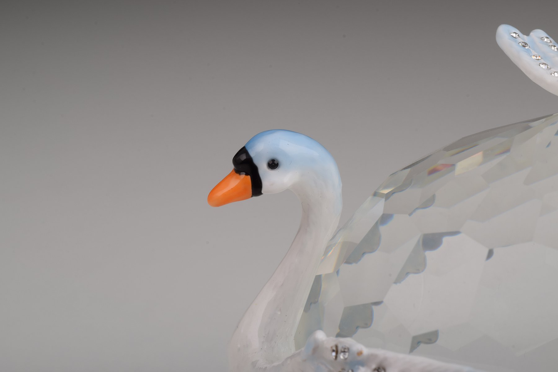 Elegant trinket box featuring two white swans on a crystal ball, adorned with Austrian crystals and plated with gold or silver.
