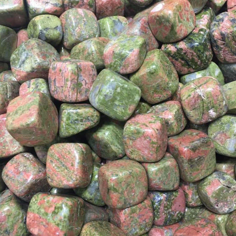 A polished Unakite cube tumbled stone showcasing its unique red and green colors, symbolizing healing and emotional balance.