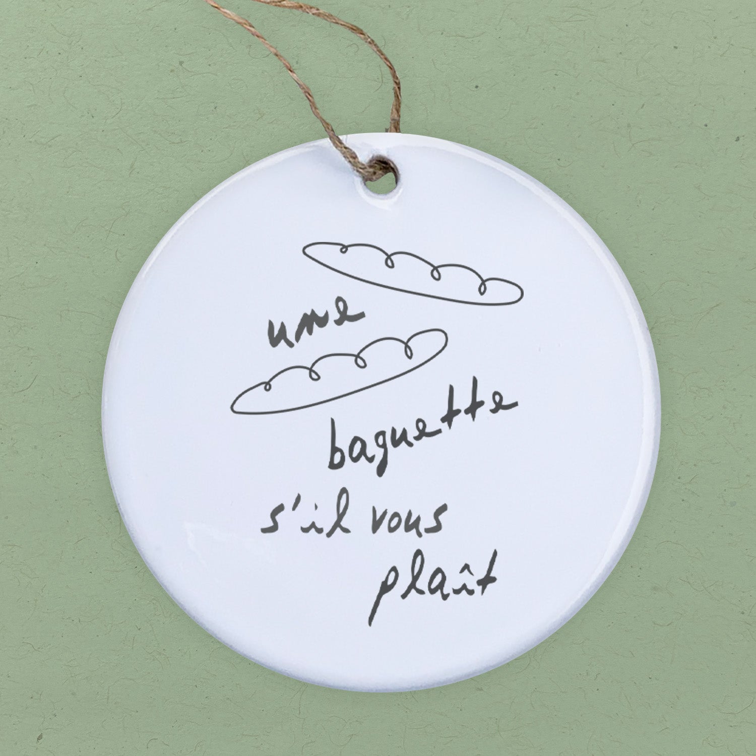 Une Baguette porcelain ornament featuring original design, 2.75 inches in diameter, perfect for gifts and home decor.