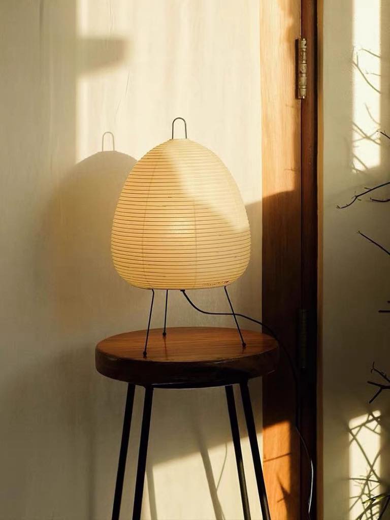 Wabi Sabi Table Lamp featuring handmade washi paper and bamboo ribbing, casting a warm glow.