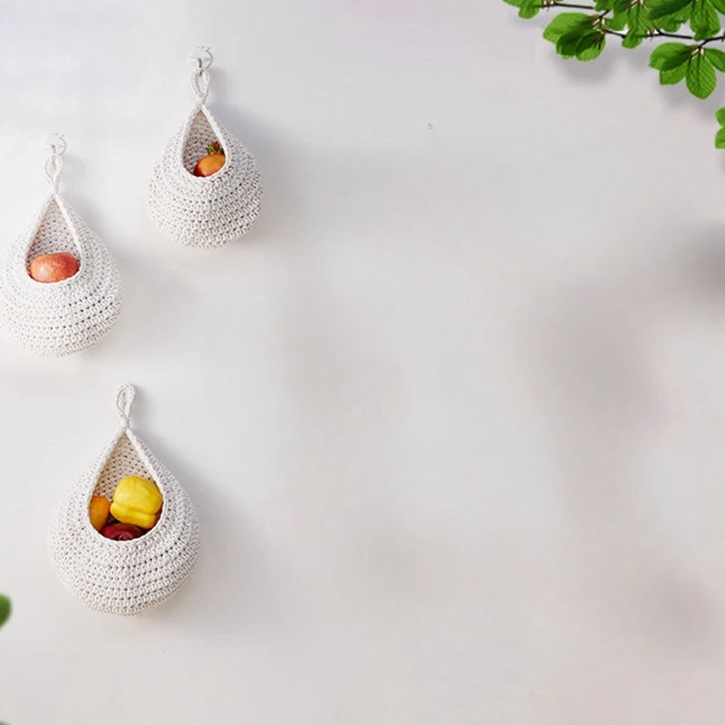 Set of three woven wall hanging fruit baskets in grey, white, and jute colors, perfect for kitchen organization.
