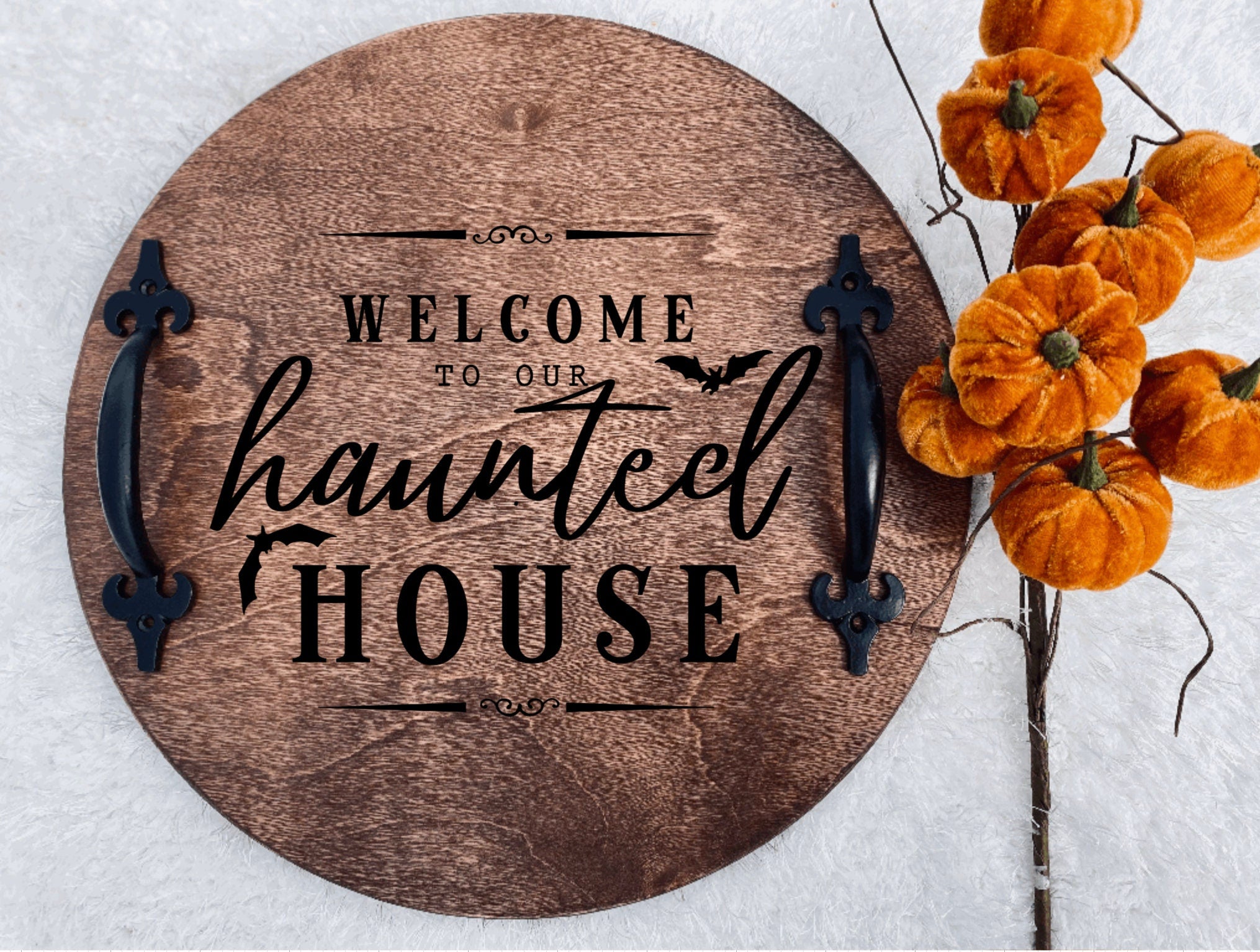 Handmade wooden serving tray with a haunted house design, featuring a rich chestnut stain and black metal handles.