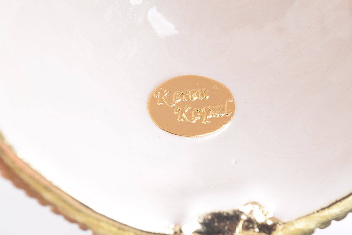 A beautifully crafted White Faberge Egg trinket box adorned with Austrian crystals and a pearl, showcasing intricate enamel painting and luxurious gold or silver plating.