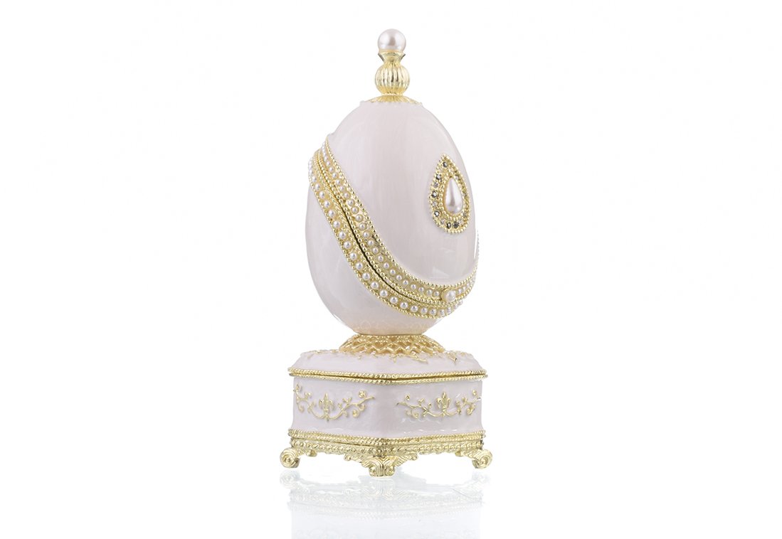 A beautifully crafted White Faberge Egg trinket box adorned with Austrian crystals and a pearl, showcasing intricate enamel painting and luxurious gold or silver plating.