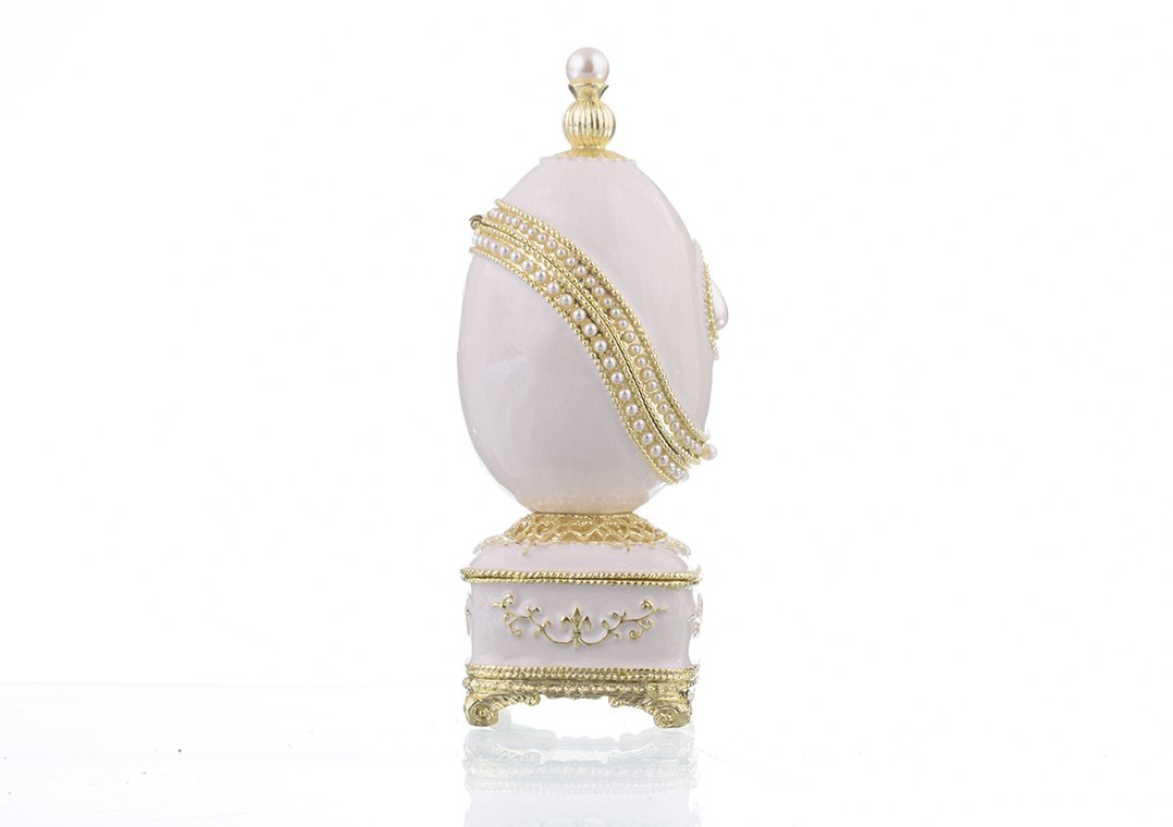 A beautifully crafted White Faberge Egg trinket box adorned with Austrian crystals and a pearl, showcasing intricate enamel painting and luxurious gold or silver plating.