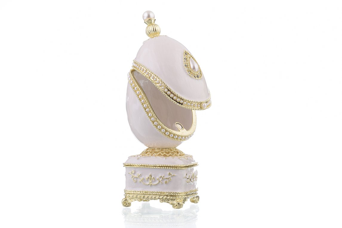 A beautifully crafted White Faberge Egg trinket box adorned with Austrian crystals and a pearl, showcasing intricate enamel painting and luxurious gold or silver plating.