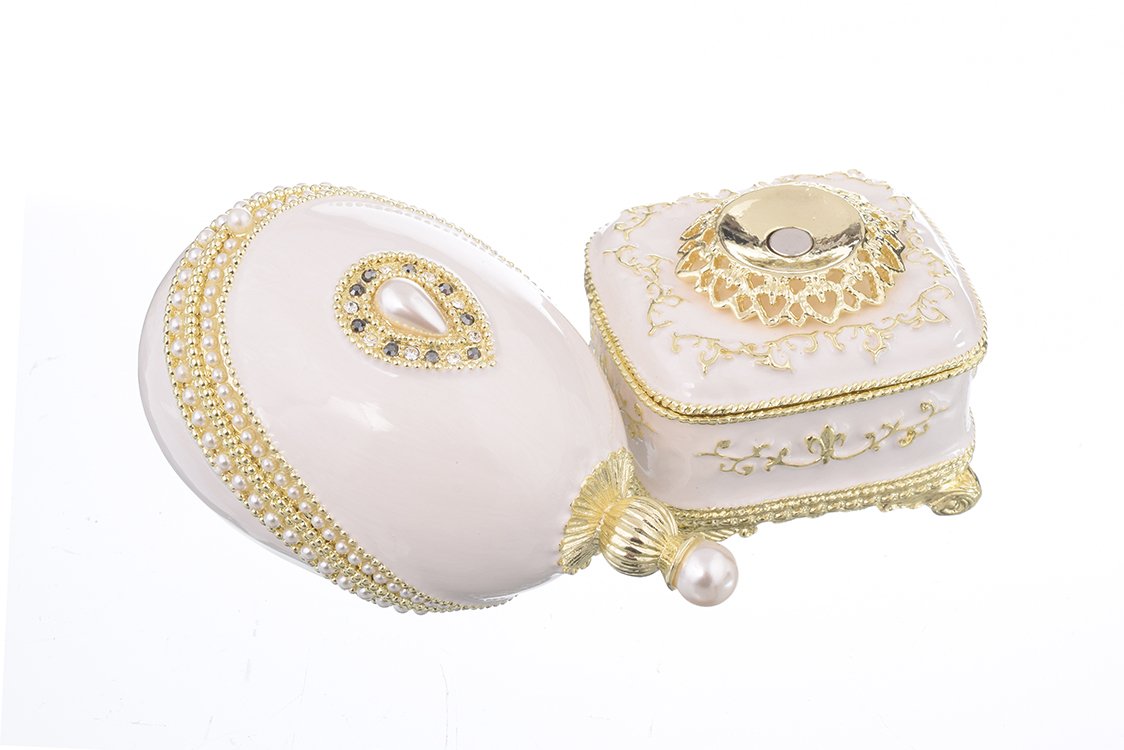 A beautifully crafted White Faberge Egg trinket box adorned with Austrian crystals and a pearl, showcasing intricate enamel painting and luxurious gold or silver plating.