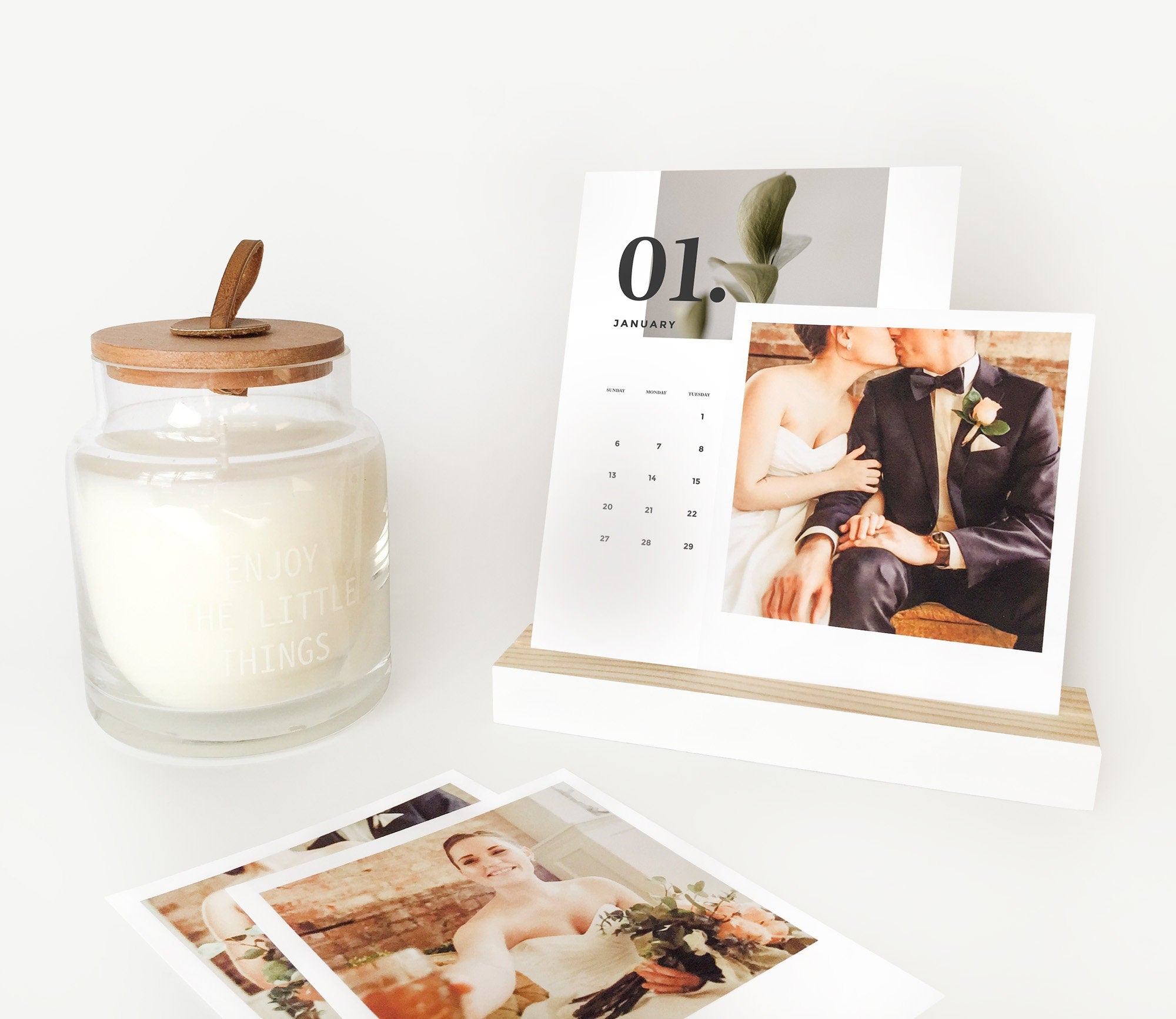 A stylish white wood bar holder displaying various photos and art prints, showcasing its versatility and elegant design.