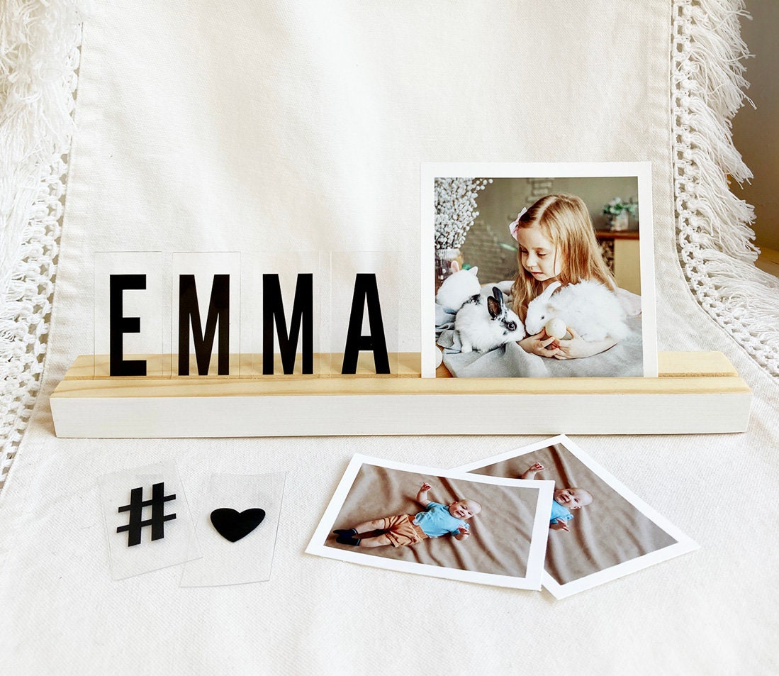 A stylish white wood photo ledge displaying various photos and art prints, showcasing its versatility and elegant design.