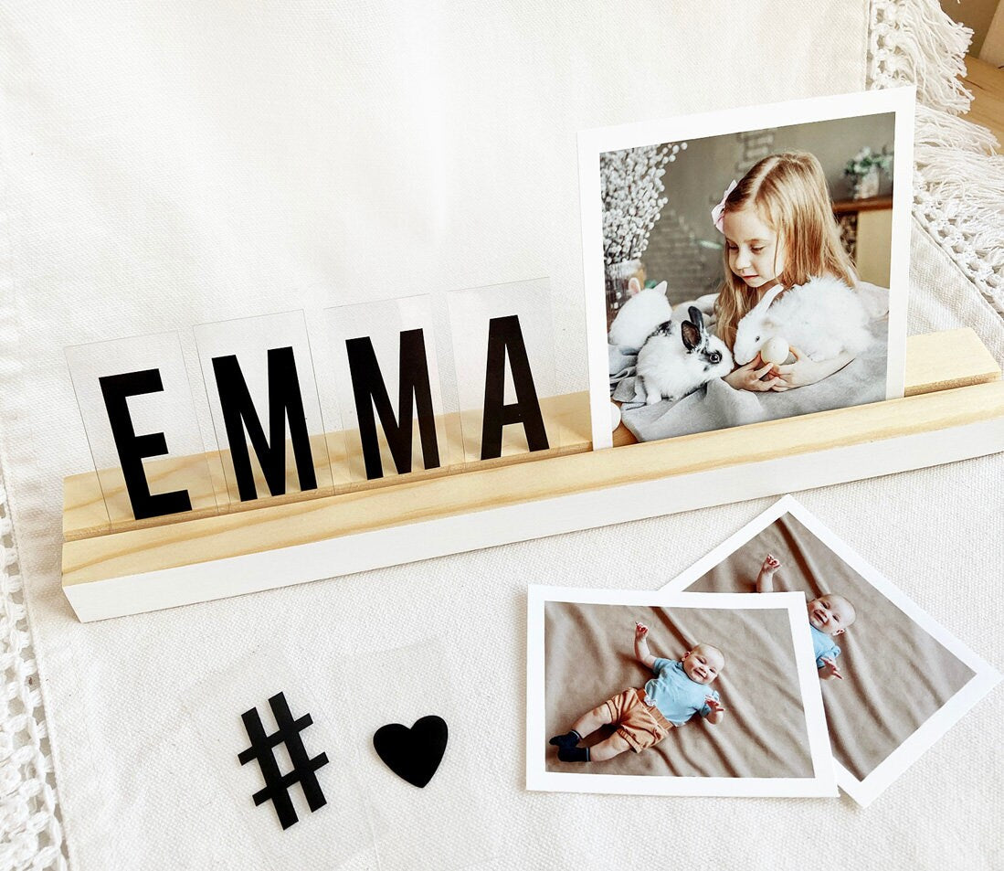 A stylish white wood photo ledge displaying various photos and art prints, showcasing its versatility and elegant design.