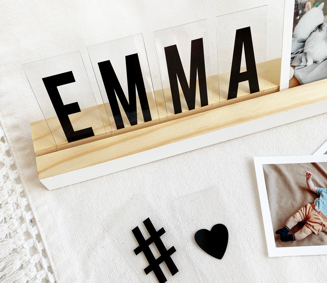 A stylish white wood photo ledge displaying various photos and art prints, showcasing its versatility and elegant design.