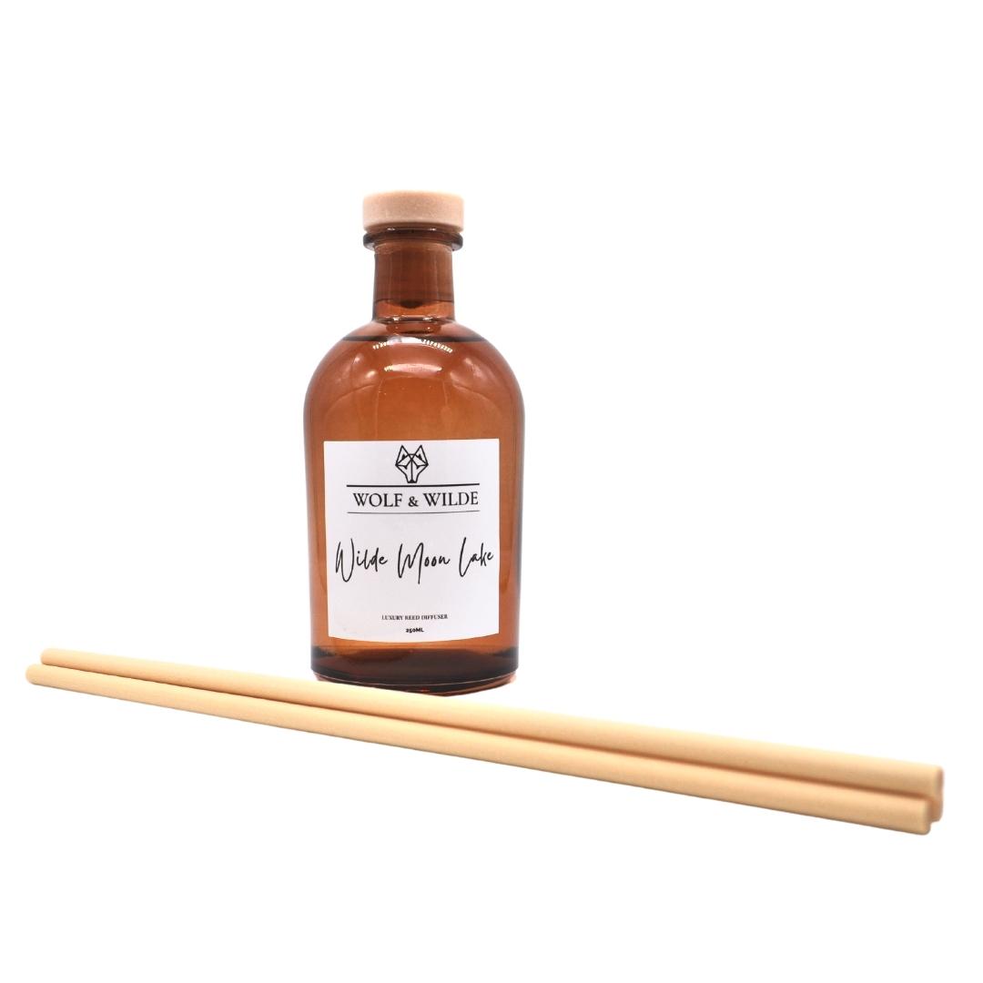 Wilde Moon Lake Apothecary Reed Diffuser in amber bottle with thick reeds, showcasing elegant design and eco-friendly materials.