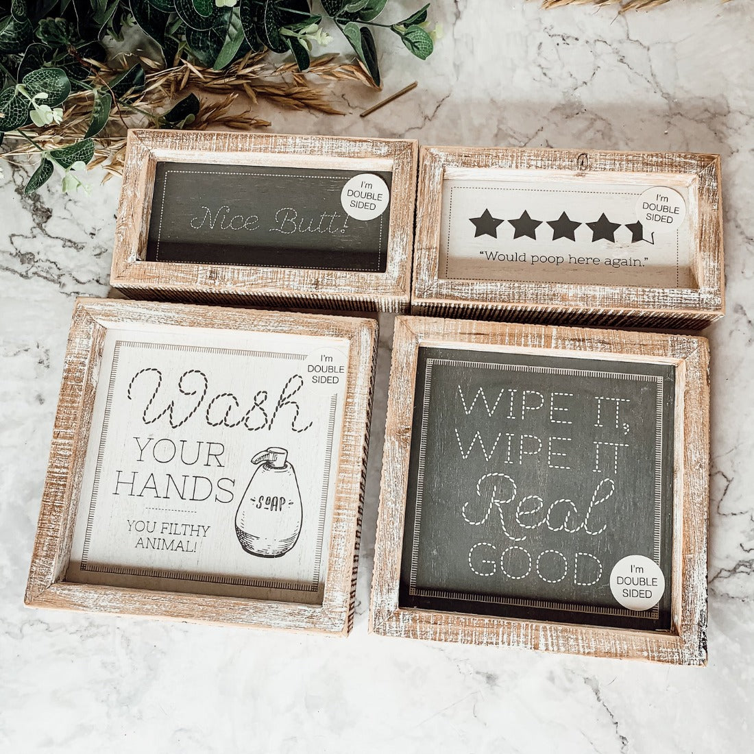 Wipe It Real Good Double-Sided sign with humorous bathroom messages in a wooden frame, displayed freestanding.