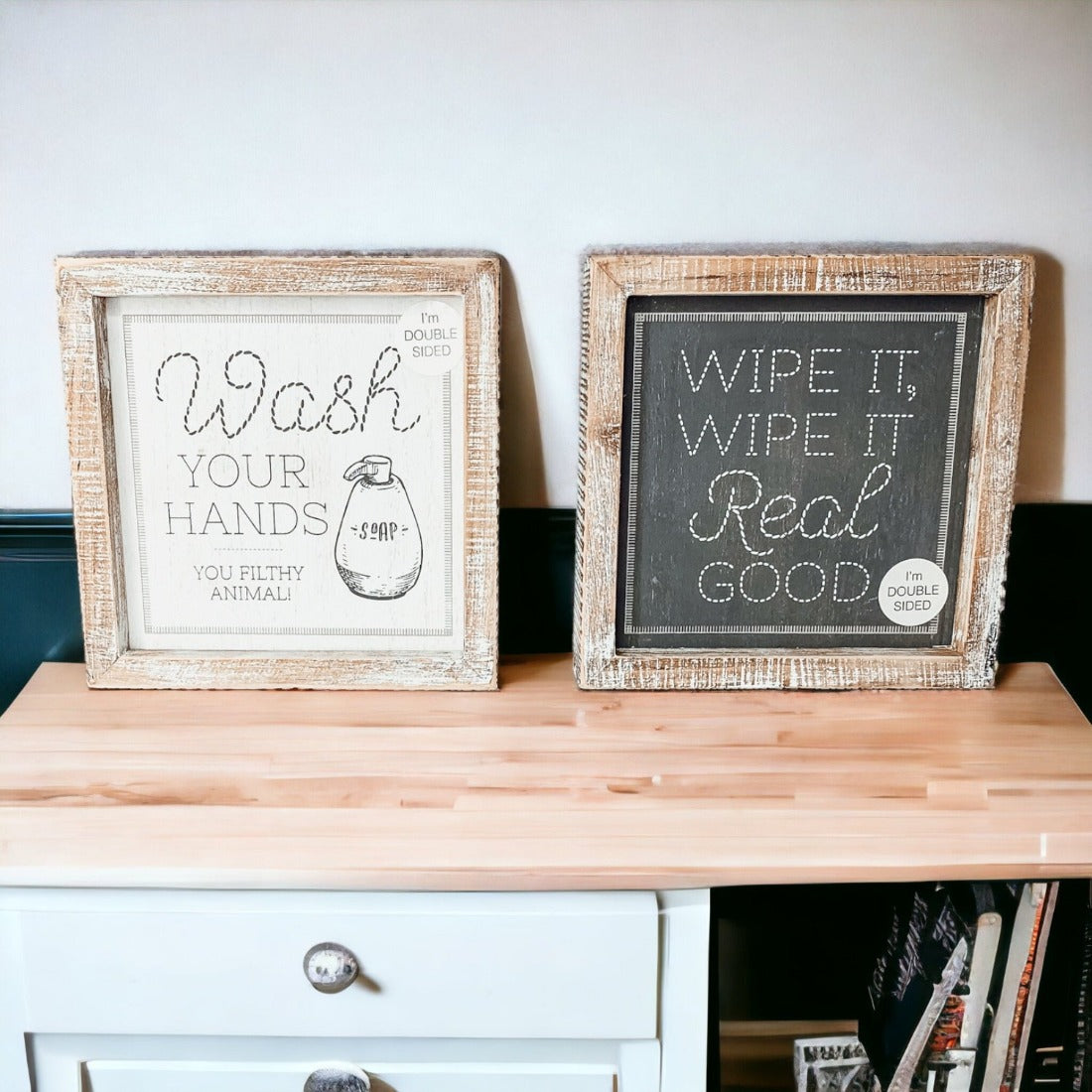Wipe It Real Good Double-Sided sign with humorous bathroom messages in a wooden frame, displayed freestanding.