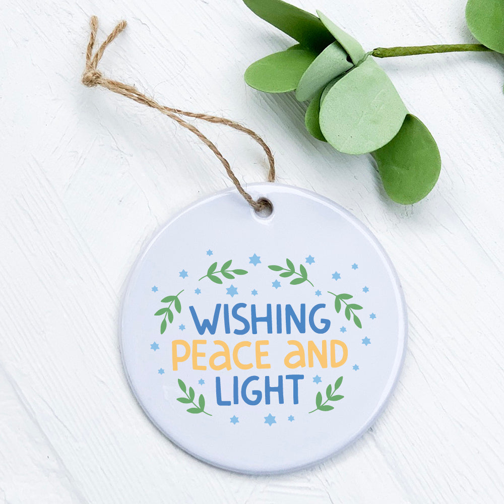 Wishing Peace and Light porcelain ornament featuring original design, smooth gloss finish, and 2.75-inch diameter.