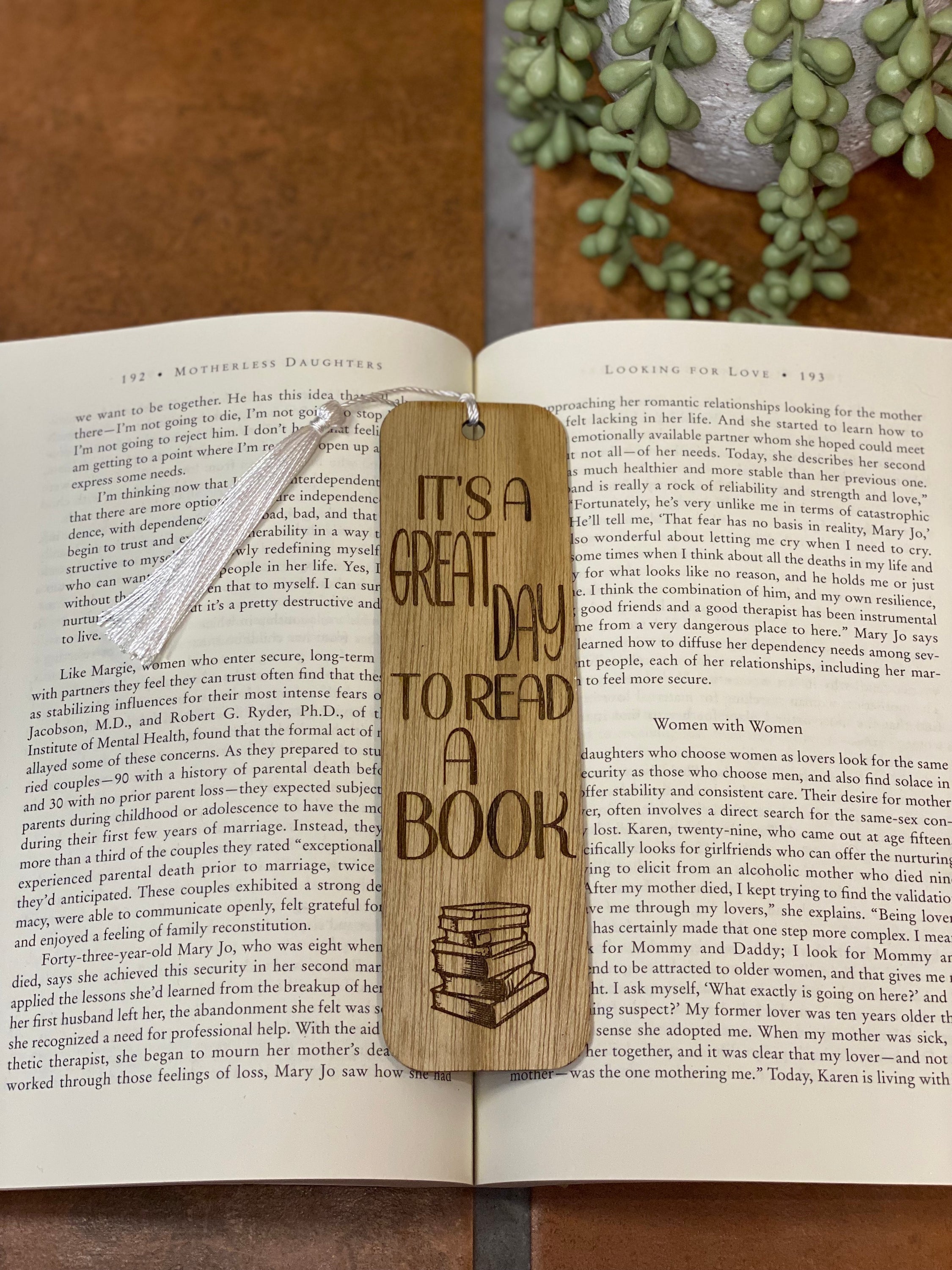 A beautifully crafted wooden bookmark with a white tassel, showcasing unique laser engraved designs.