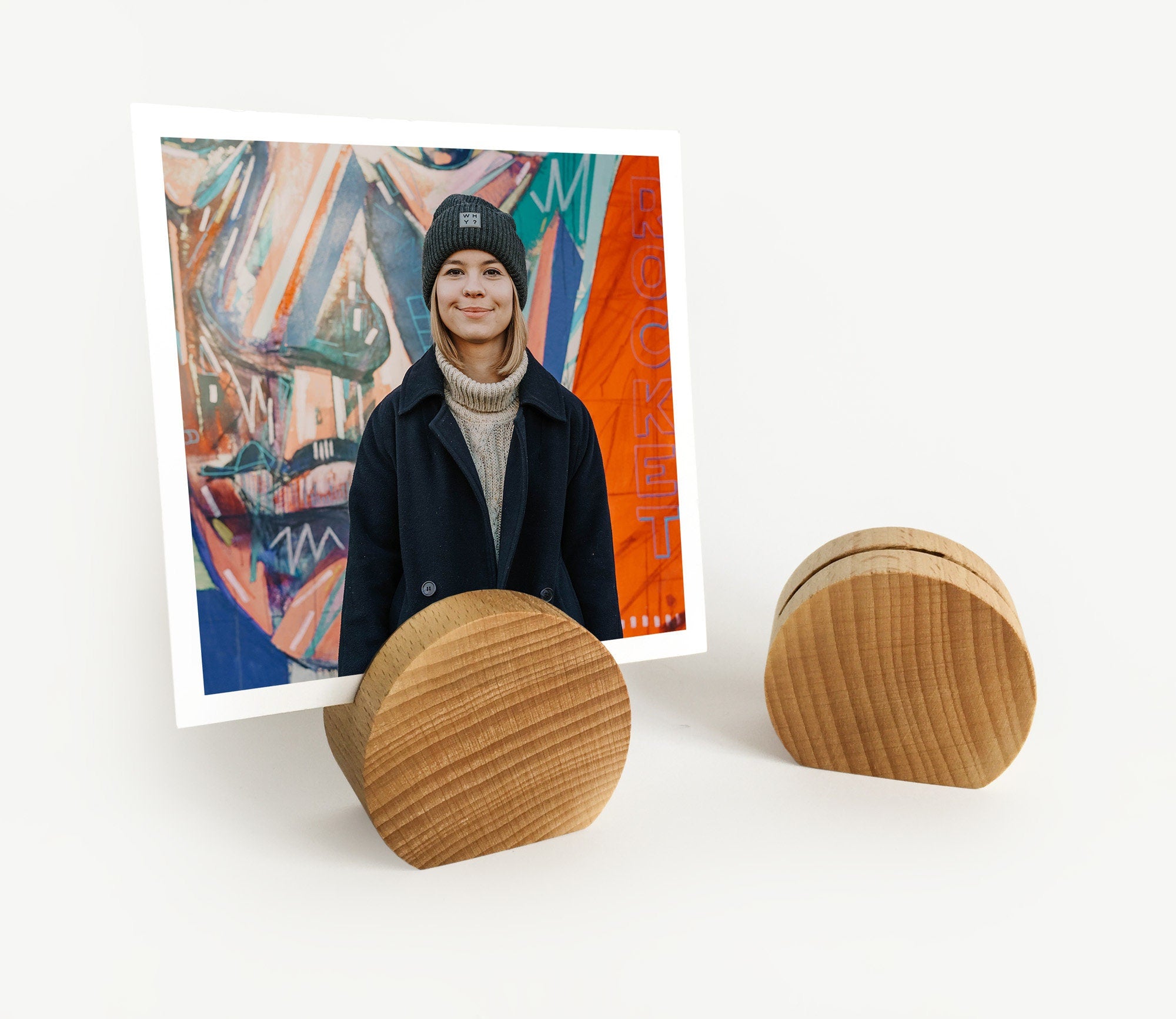 A handcrafted wooden moon card holder displaying various photos and art prints, showcasing its elegant design and eco-friendly material.