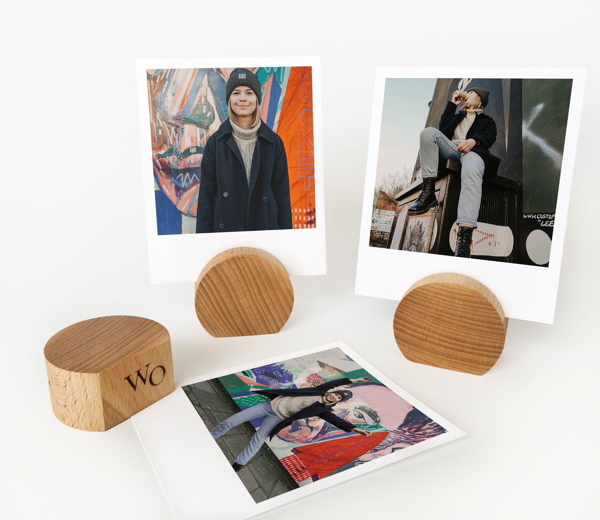 A handcrafted wooden moon card holder displaying various photos and art prints, showcasing its elegant design and eco-friendly material.