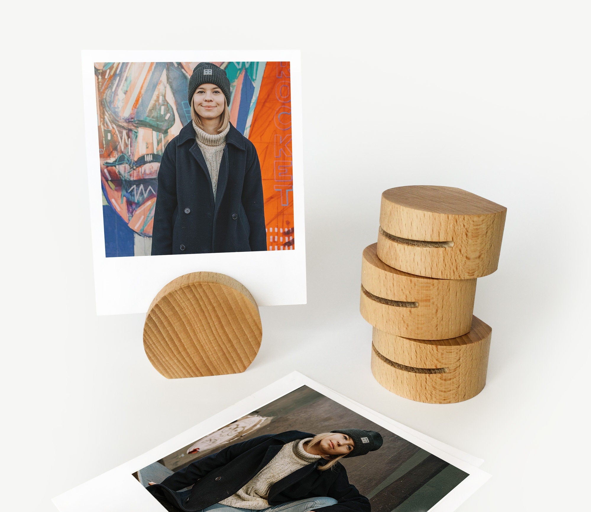 A handcrafted wooden moon card holder displaying various photos and art prints, showcasing its elegant design and eco-friendly material.