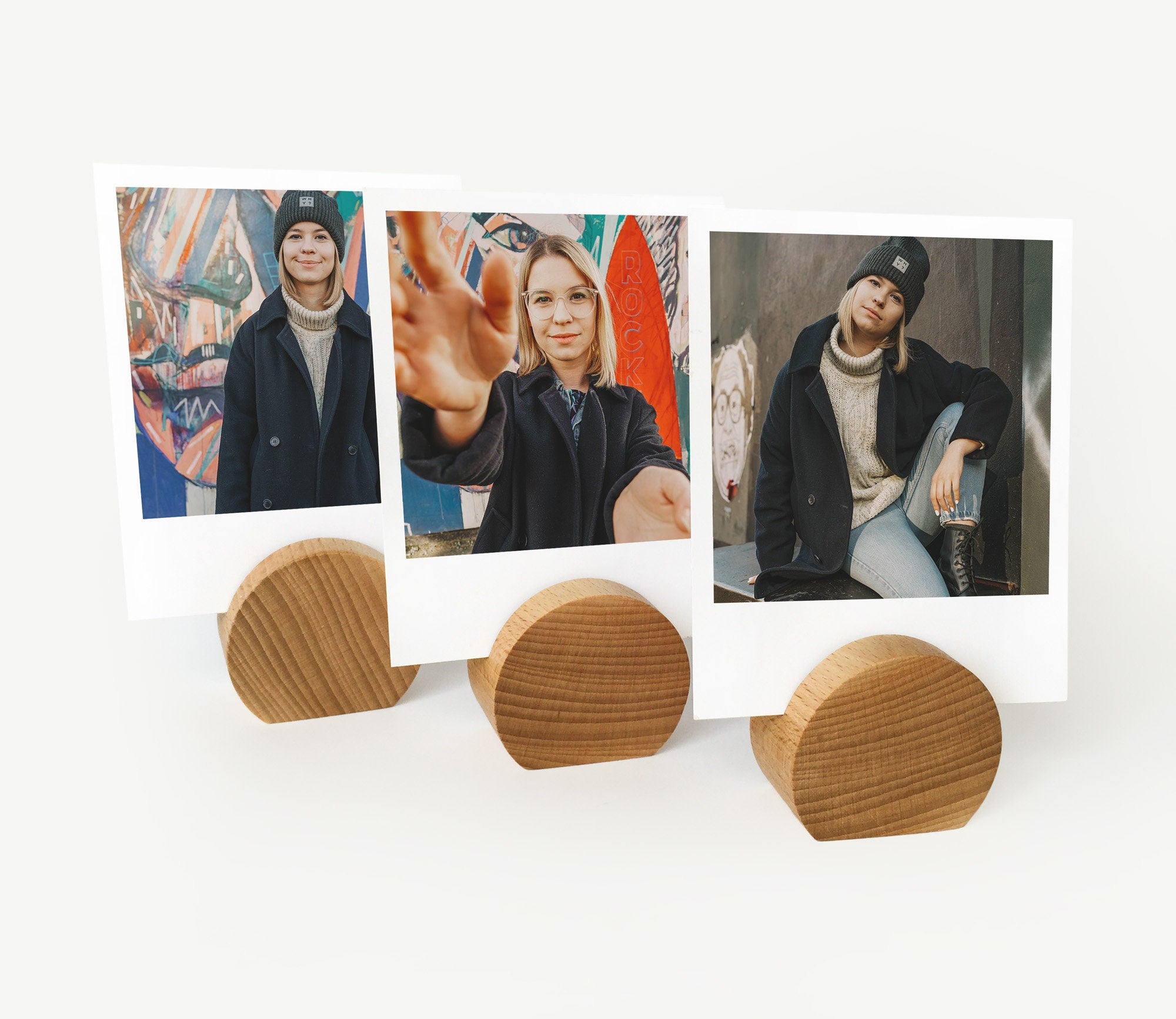 A handcrafted wooden moon card holder displaying various photos and art prints, showcasing its elegant design and eco-friendly material.