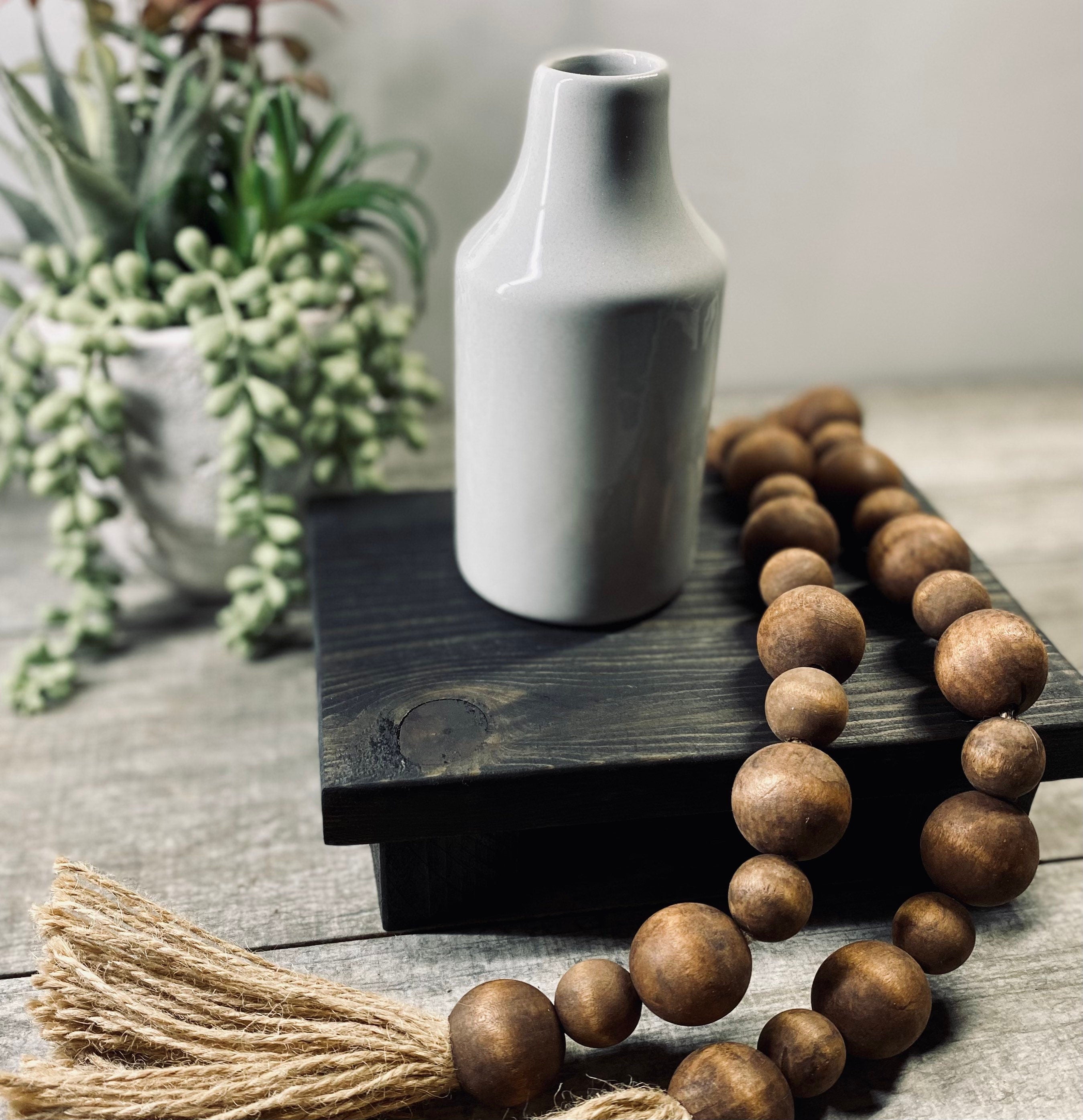 Handmade wooden riser in black stain, perfect for displaying soaps, candles, or plants, showcasing unique wood grain patterns.