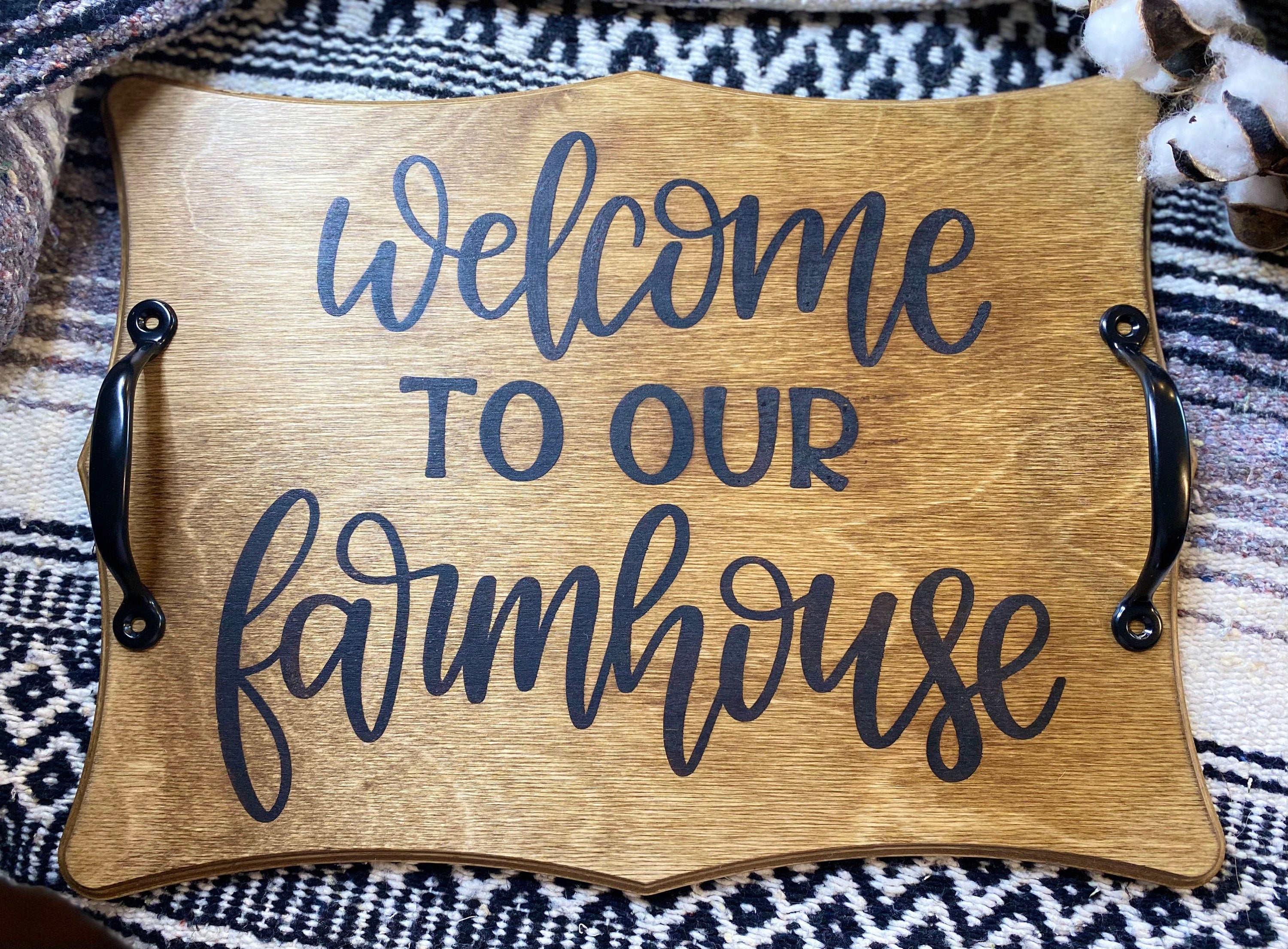 Handmade wooden serving tray with rustic pine stain and cast iron handles, featuring 'Welcome to our Farmhouse' design.