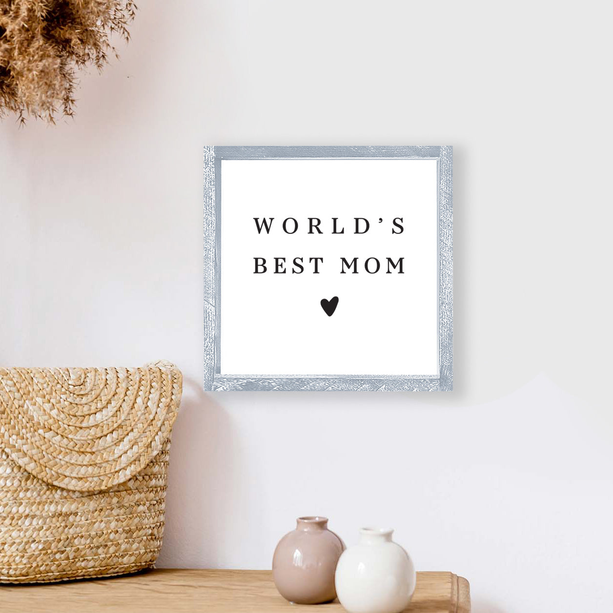 A beautifully crafted 8x8 inch wood sign that reads 'World's Best Mom', featuring a rustic pine wood frame and waterproof black text on a white background.