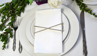 Set of 4 shiny silver X Wrap napkin wraps elegantly displayed in a stylish box.