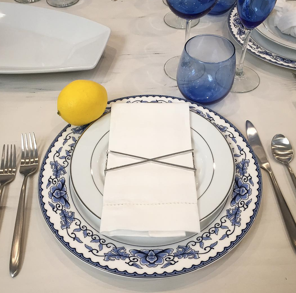 Set of 4 shiny silver X Wrap napkin wraps elegantly displayed in a stylish box.