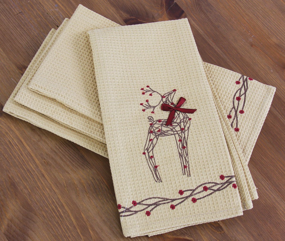 Set of 4 rustic tea towels featuring intricate reindeer and holly embroidery on a burlap background, perfect for holiday decor.