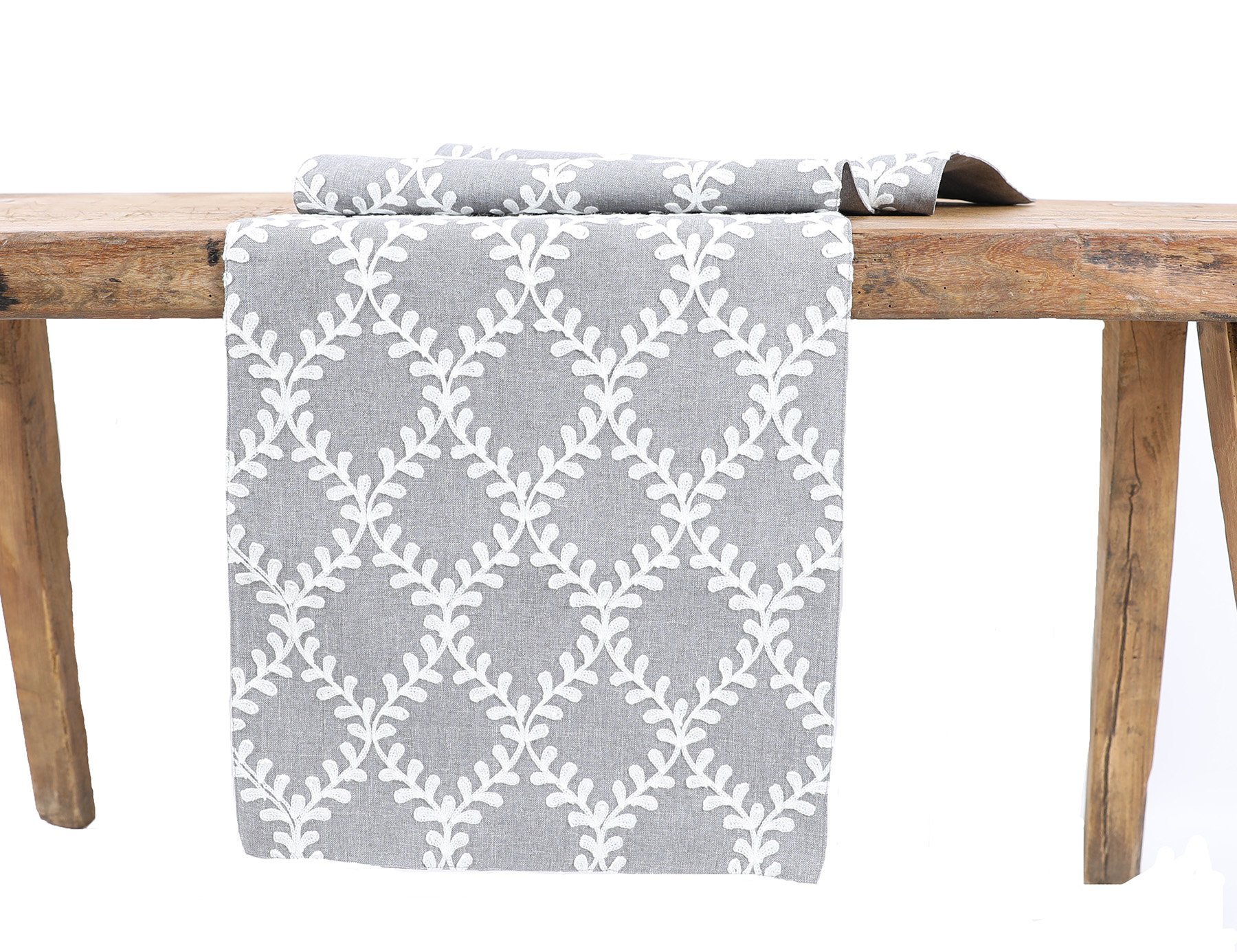 XD19200 Piluki Leaf Crewel Embroidered Table Runner featuring off-white leaves on textured gray fabric, elegantly designed for dining decor.