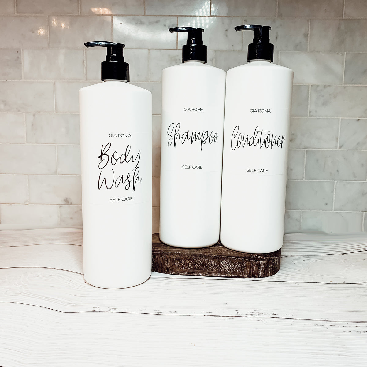 A set of 32oz plastic white dispensers with waterproof labels, featuring a black pump and a white flip cap, ideal for home and office use.