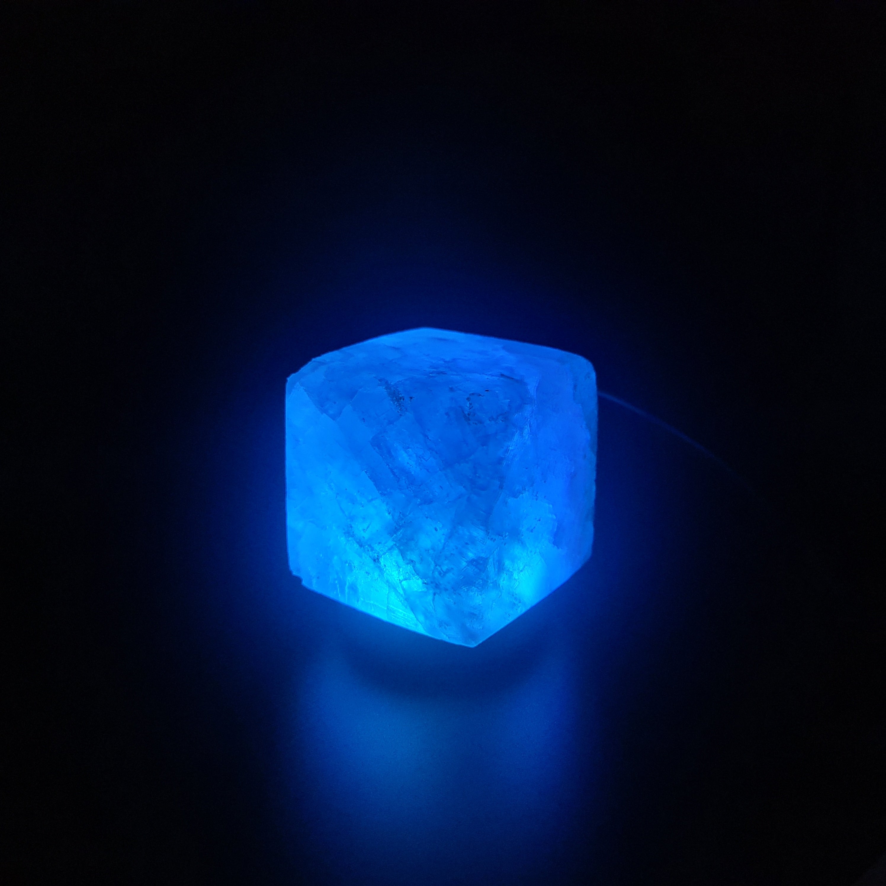 Himalaya USB Farbwechsellampe aus rosa Himalaya-Salz auf Holzsockel, strahlt warmes, beruhigendes Licht aus.