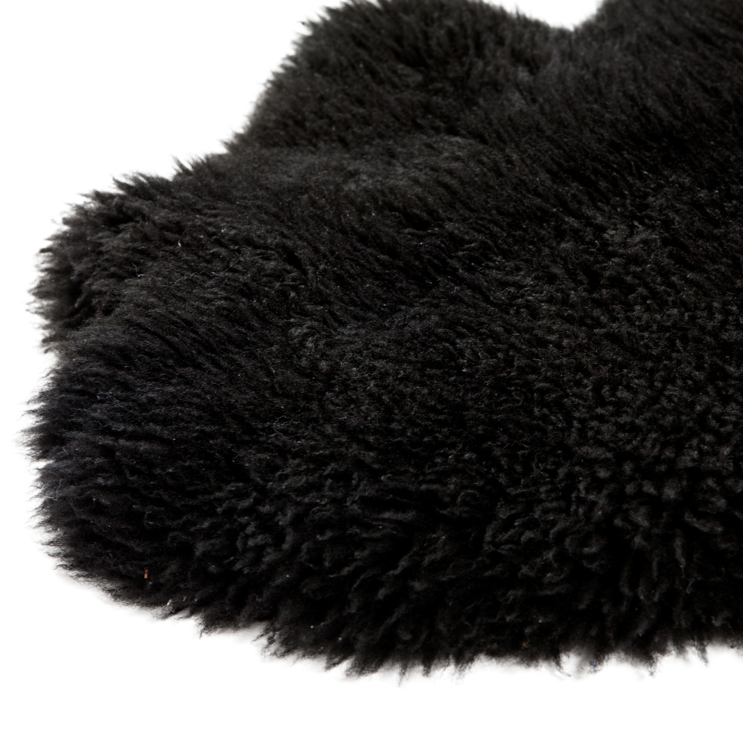 Natuurlijk zwart schapenvacht van 100 x 65 cm, zacht en wollig, perfect voor decoratie en comfort in huis en tuin.
