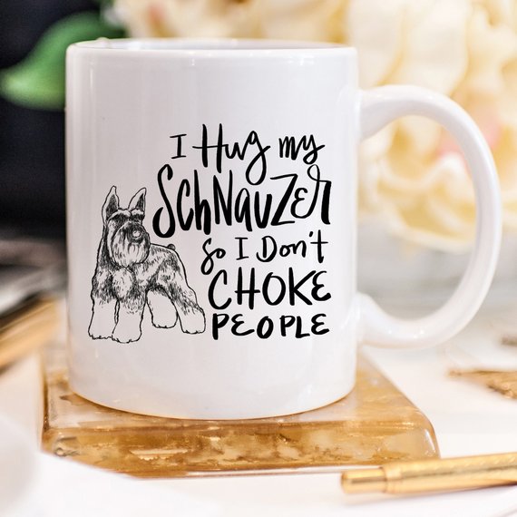 A humorous 11oz coffee mug featuring the phrase 'I Hug My Schnauzer So I Don't Choke People', designed for dog lovers.