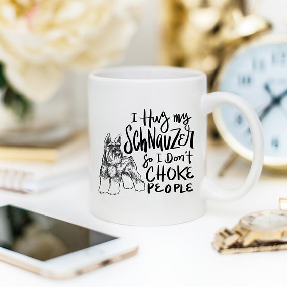 A humorous 11oz coffee mug featuring the phrase 'I Hug My Schnauzer So I Don't Choke People', designed for dog lovers.
