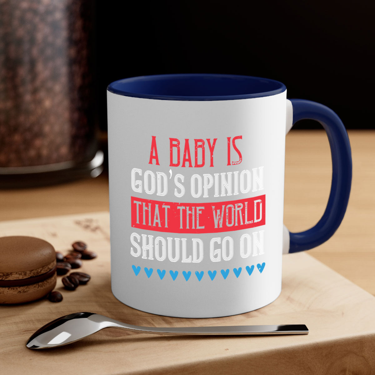 A stylish two-tone ceramic mug with a glossy finish, featuring the phrase 'A baby is God’s opinion that the world should go on' and a comfortable C-shaped handle.