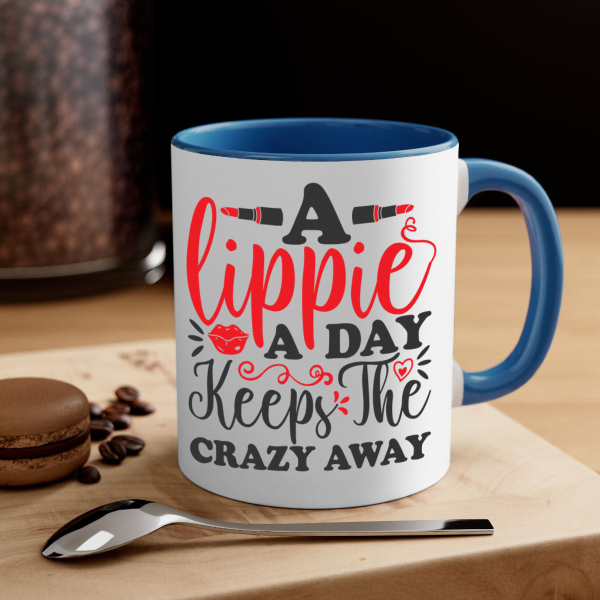 Two-tone ceramic coffee mug with colorful handle and interior, featuring the phrase 'a lippie a day keeps the crazyaway'.