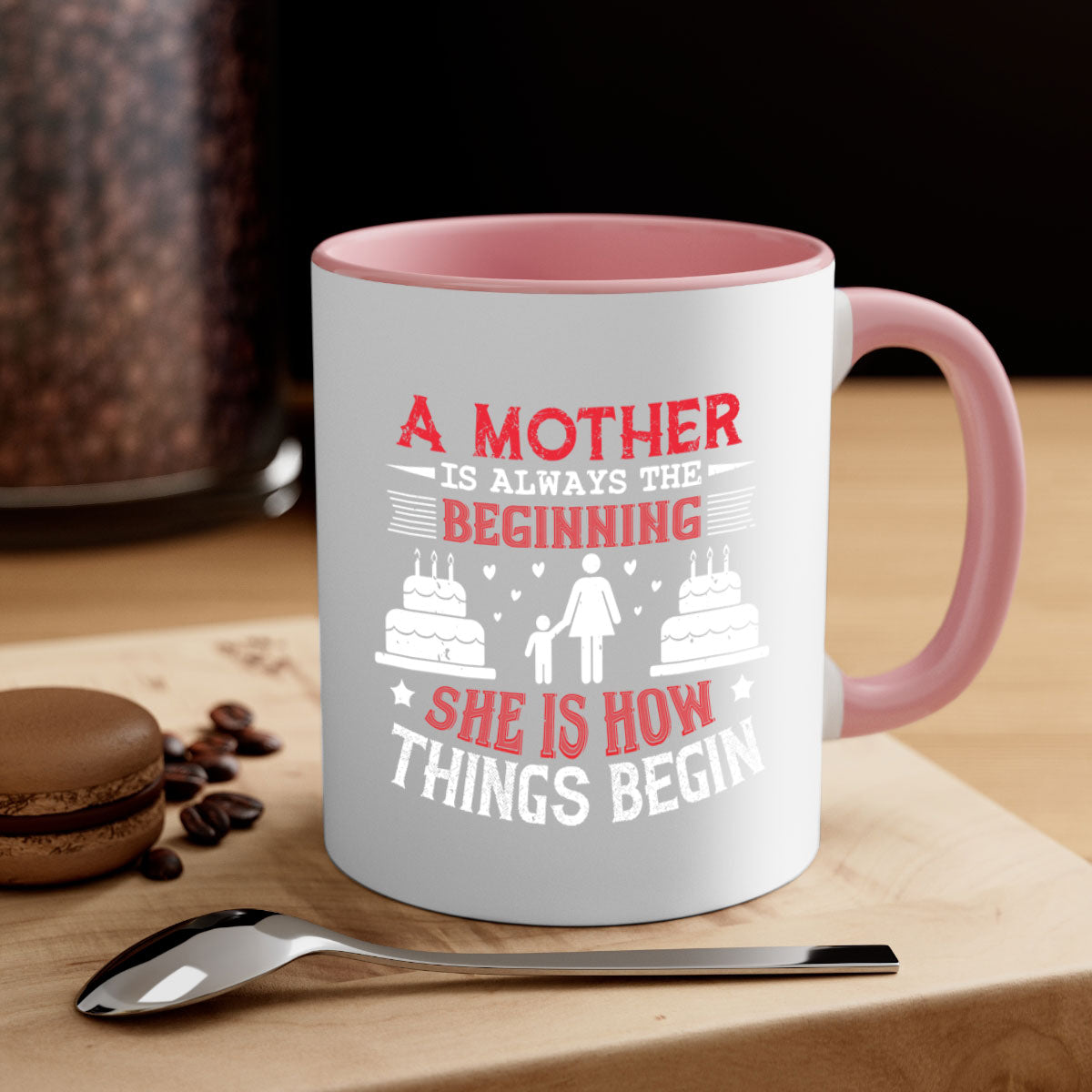 A two-tone ceramic coffee mug with a colored handle and glossy finish, featuring the text 'A Mother is Always the Beginning' for Mother's Day.