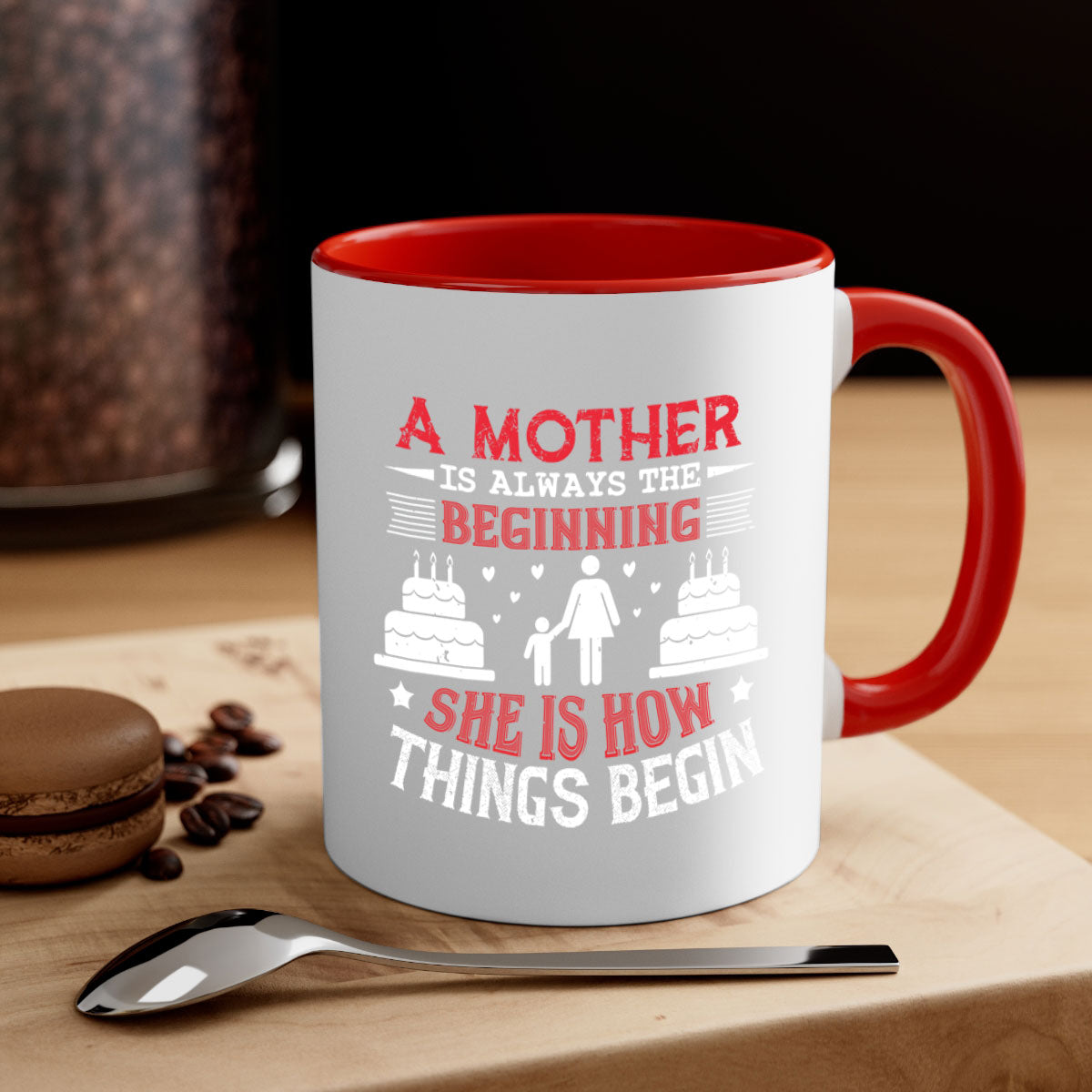 A two-tone ceramic coffee mug with a colored handle and glossy finish, featuring the text 'A Mother is Always the Beginning' for Mother's Day.