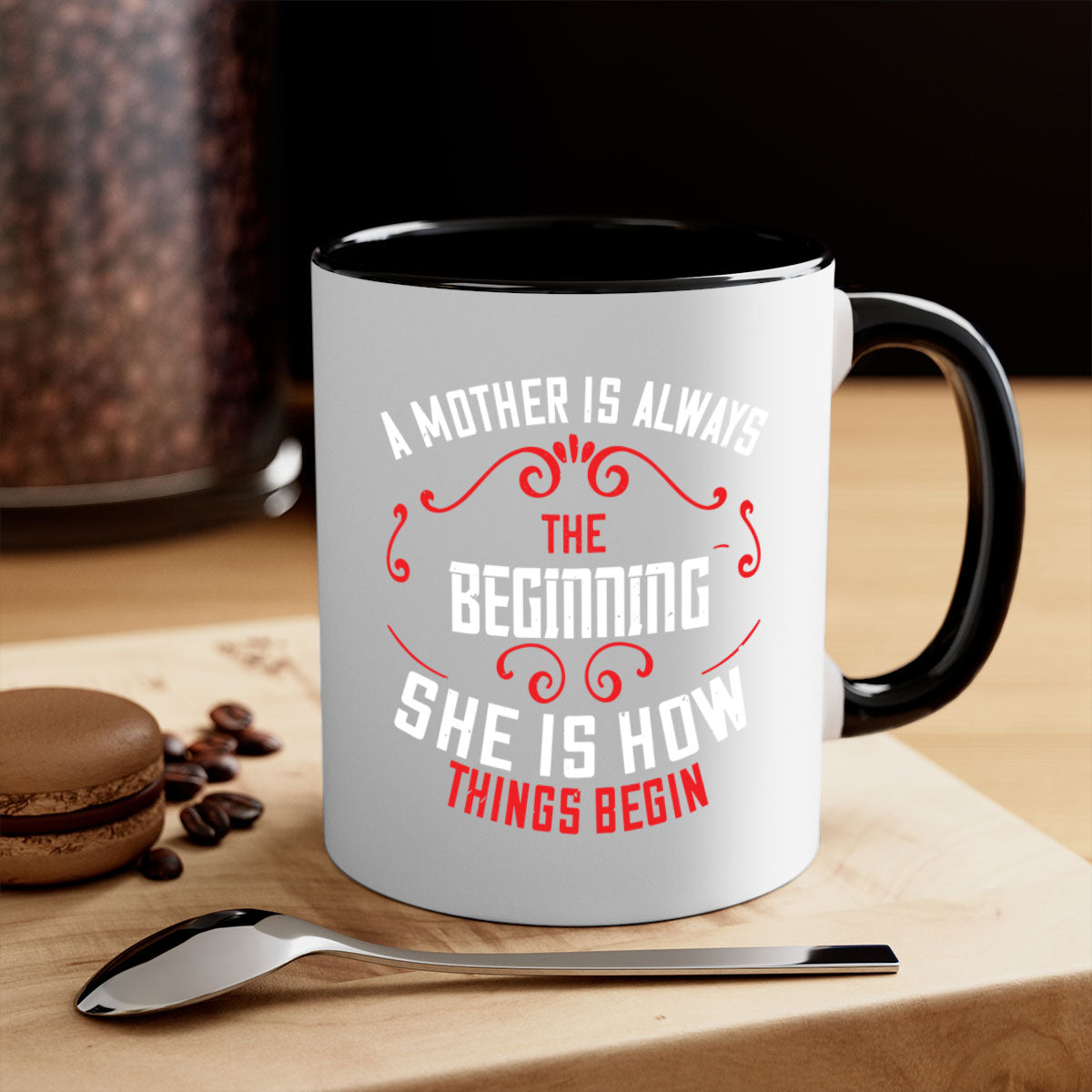 A two-tone ceramic mug with a colored handle and interior, featuring the phrase 'A Mother is Always the Beginning' in elegant typography.