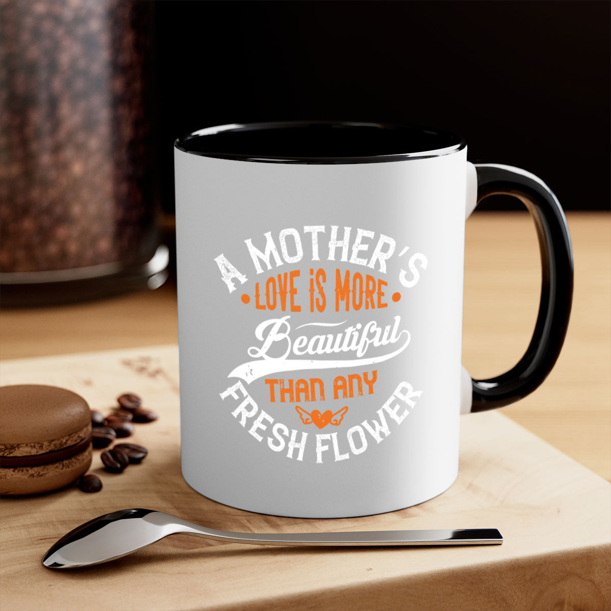 A two-tone ceramic coffee mug with a colored handle and interior, featuring the phrase 'A Mother's Love is More' in an elegant font.