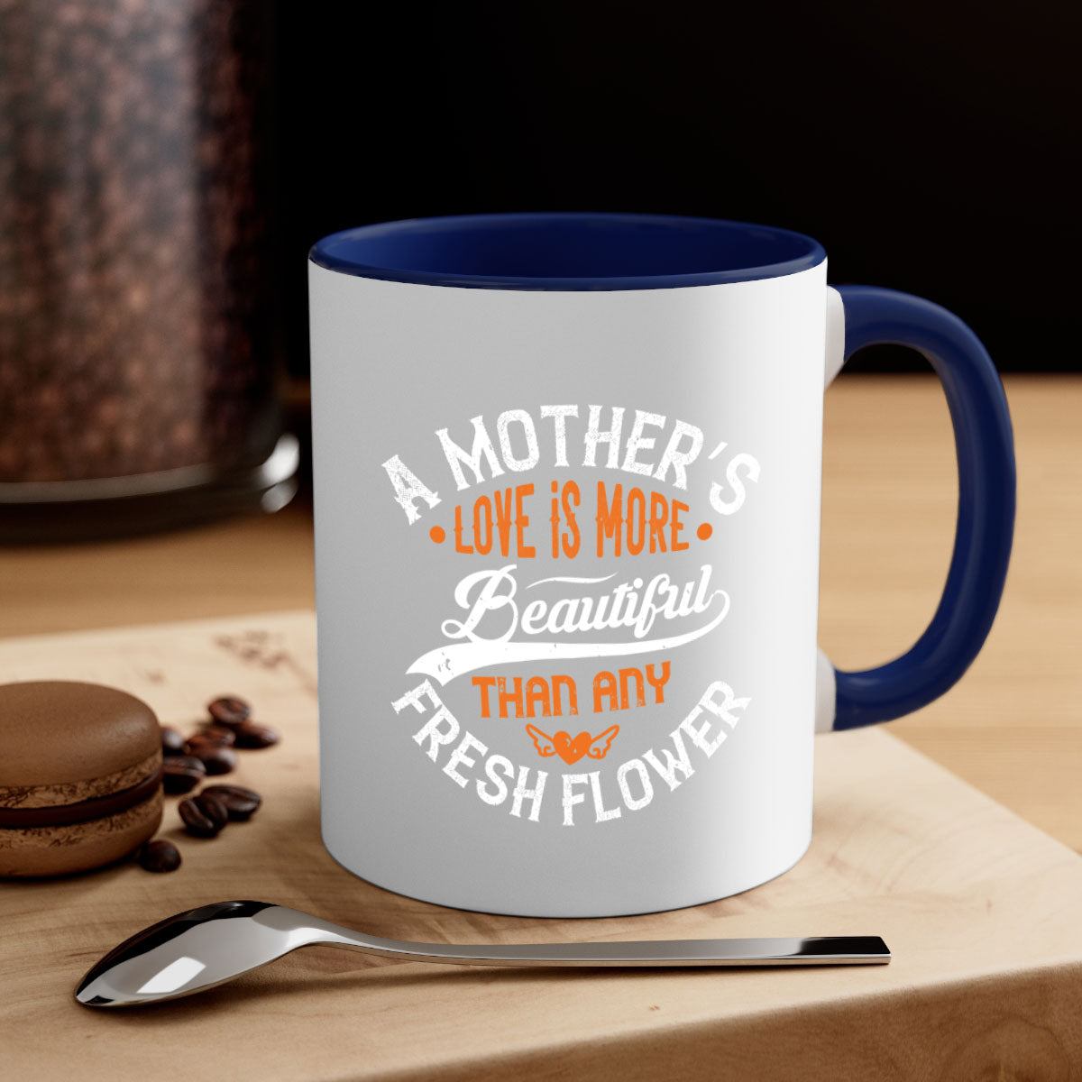 A two-tone ceramic coffee mug with a colored handle and interior, featuring the phrase 'A Mother's Love is More' in an elegant font.