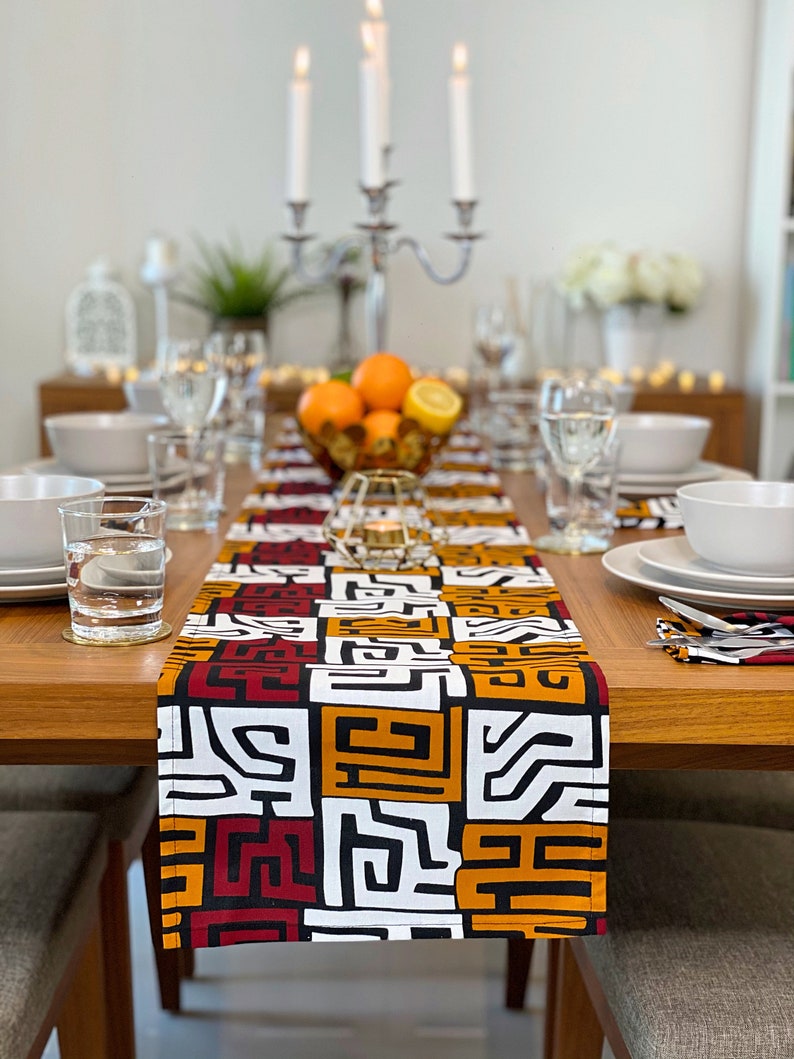 African MudCloth Table Runner with six matching napkins, featuring a vibrant tribal design in black, white, burgundy red, and orange.