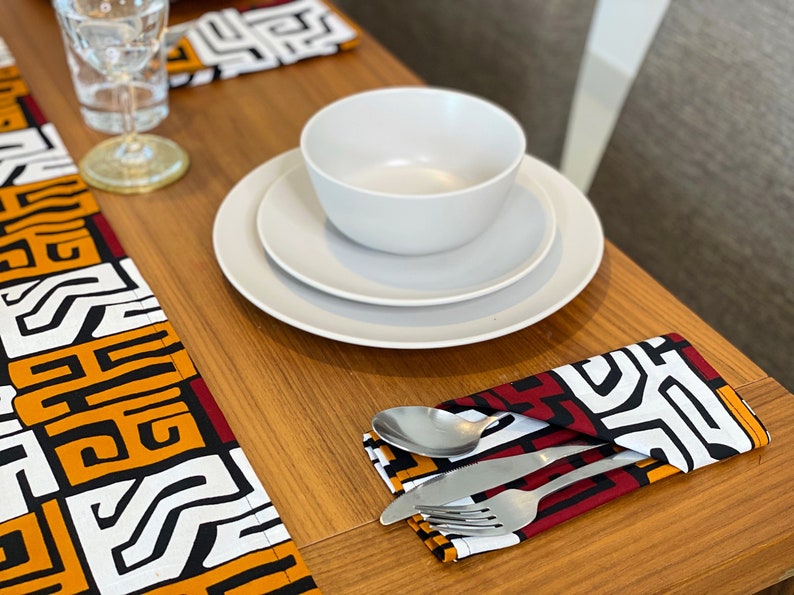 African MudCloth Table Runner with six matching napkins, featuring a vibrant tribal design in black, white, burgundy red, and orange.
