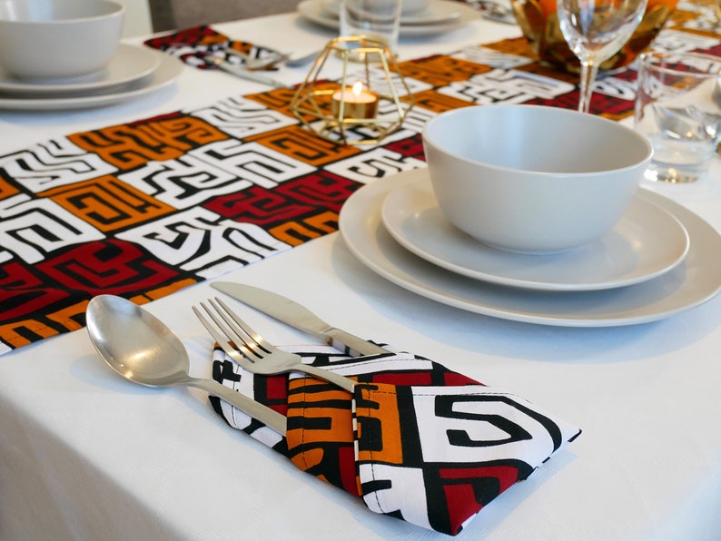 African MudCloth Table Runner with six matching napkins, featuring a vibrant tribal design in black, white, burgundy red, and orange.