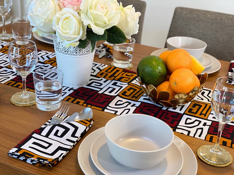 African MudCloth Table Runner with six matching napkins, featuring a vibrant tribal design in black, white, burgundy red, and orange.