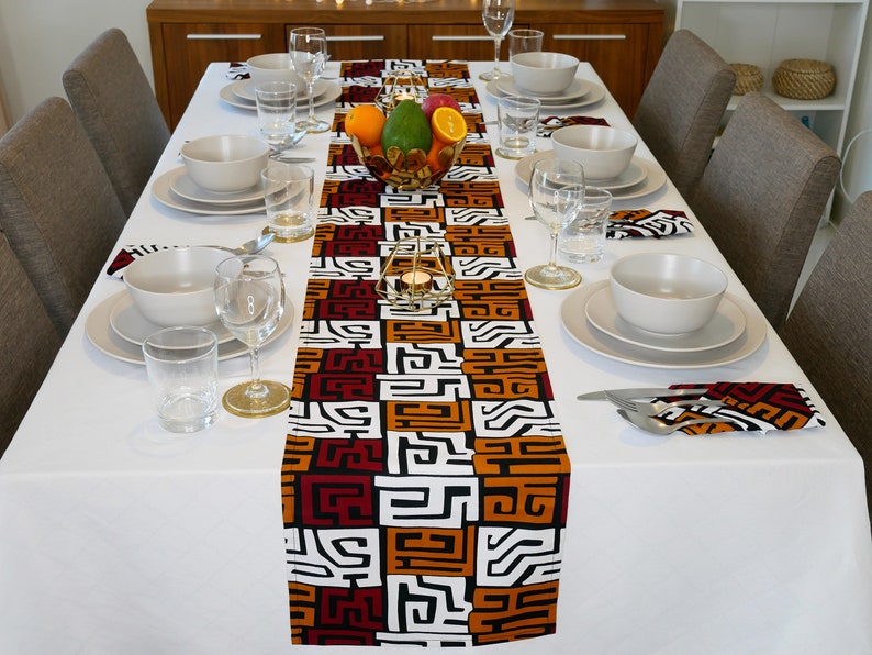 African MudCloth Table Runner with six matching napkins, featuring a vibrant tribal design in black, white, burgundy red, and orange.