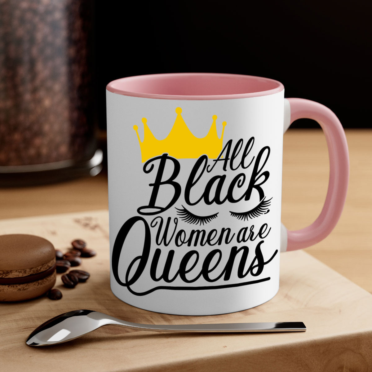 A stylish two-tone ceramic mug featuring the phrase 'All Black Women Are Queens' with a colored handle and glossy finish.